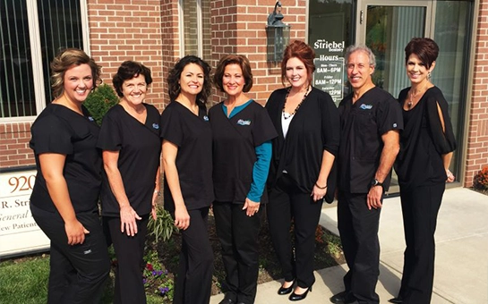 Dentist John R. Striebel With Team Outside