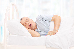 Mature man sleeping in a comfortable bed at home